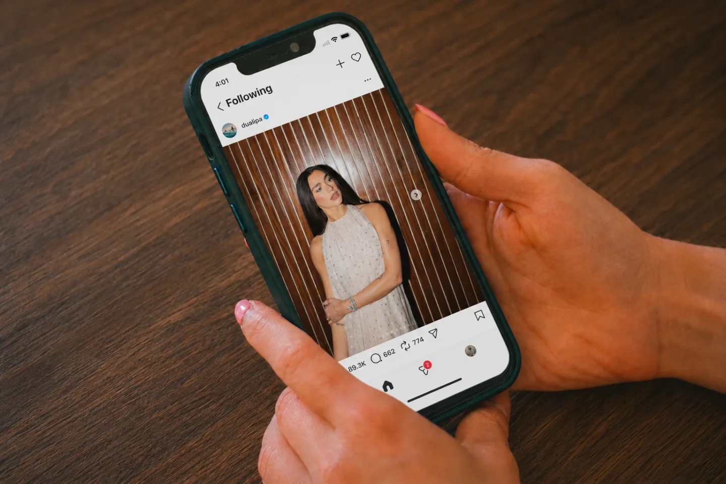 Hands holding an iPhone showing the Instagram mobile site with no Reels tab in the bottom navigation — only Home, Search, and profile — after Nope is enabled.
